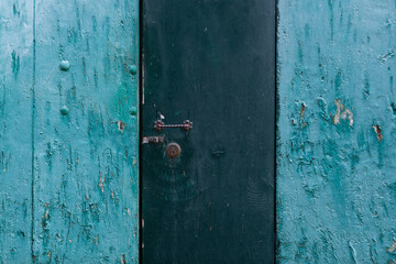 Detail of a wooden door with two-tone blue paint