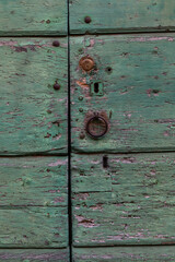 Green weathered painted old wooden door in Tuscany, Italy