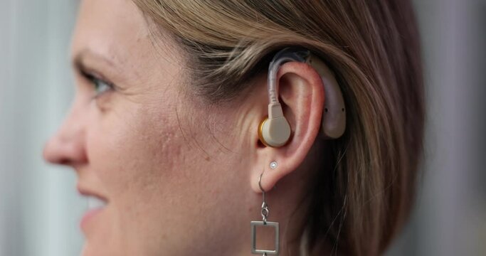 Young woman and hearing aid on ear