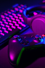Headphones, joystick and computer keyboard on black table
