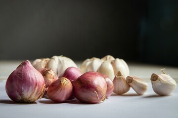 Composition of red onions, garlic and various spices isolated on white background, top view