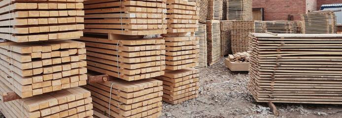 A large number of wooden pallets in production. Wooden pallets are in the racks. Narrow banner.