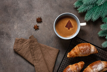Christmas breakfast with fresh croissants and hot coffee, dark rustic background. Top view, copy...