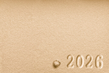 Fototapeta na wymiar Imprints of numbers 2026 new year and a shell left side on a golden sand