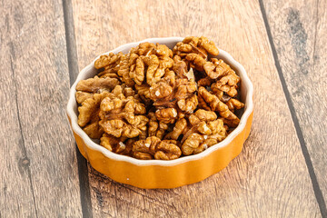 Cracked unshelled walnut in the bowl