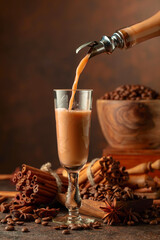 Irish cream and coffee liquor is poured from a bottle into a glass.
