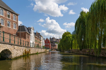 Street view with stepped gables in the Belgian city of Gent against a blue sky with white clouds,...