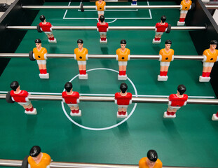 Football - board game with players, soccer ball and green field. Foosball table, close-up.