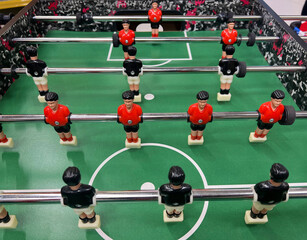 Football - board game with players, soccer ball and green field. Foosball table, close-up.