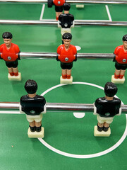 Football - board game with players, soccer ball and green field. Foosball table, close-up.