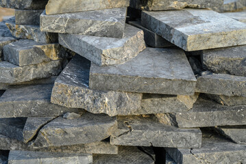 pieces of stone for paving lie in a heap as a background 2
