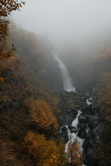 waterfall in the mountains in the autumn forest