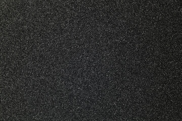 black sandpaper texture background, close-up
