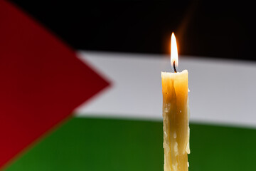 Mourning in country palestine. A burning candle on background of the palestine flag. Victims of...