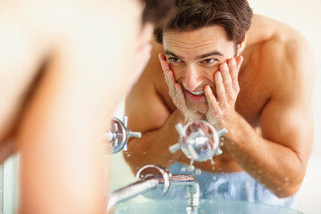 Man, washing and face with water in bathroom for clean, hygiene or germs in morning. Happy person,...