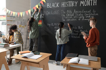 Group of school children preparing for the Black History Month, they decorating classroom and...