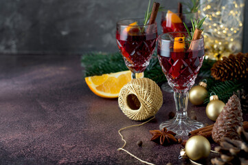 Winter, Christmas composition with crystal glasses with gluwein, mulled wine and New Year's decor, garland, decorations, spices, Christmas tree. New Year card, holiday. Horizontal, space for copying.