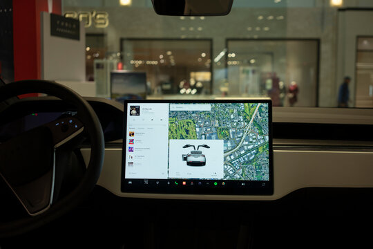Tigard, OR, USA - Nov 30, 2023: The center touchscreen in a new Tesla Model X on display at a Tesla showroom shows that its front driver side door and double-hinged falcon wing doors are open.