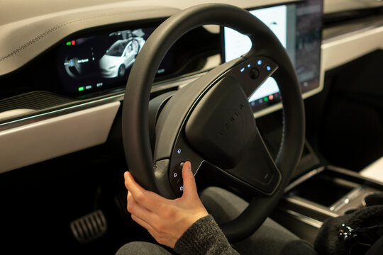 Tigard, OR, USA - Nov 30, 2023: A woman adjusts the steering wheel position by using the left scroll button in a new Tesla model X at a Tesla showroom in Tigard, Oregon.