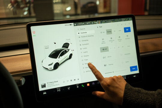 Tigard, OR, USA - Nov 30, 2023: A woman tries out the functions on the center touchscreen in a new Tesla model Y at a Tesla showroom in Tigard, Oregon.