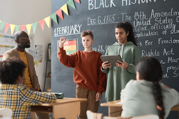 Two classmates using digital tablet to present their report about Black HIstory Month during a...