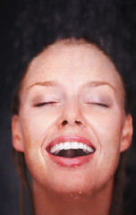 Fototapeta premium Shower, water splash and face of happy woman in a house for hygiene, fresh or stress relief closeup. Smile, bathroom and female person relax with cleaning, wellness or body care, skincare or routine