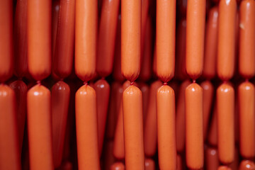 Appetizing sausages on racks in a sausage shop. Sausage production.