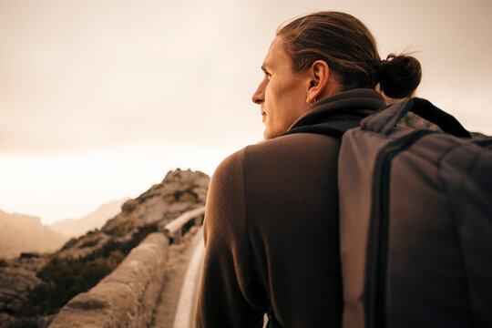 Rear view of young man with man bun looking away during vacation