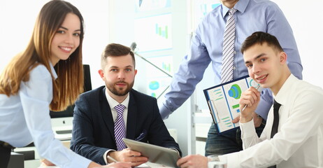 Team of colleagues is working on new startup project in office. Business document analysis and...