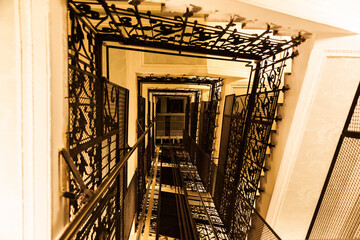 An old elevator shaft inside a house with forged steel railings on the inside. © Сергей Жмурчак