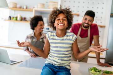 Happy african american parents and child having fun preparing healthy food in kitchen