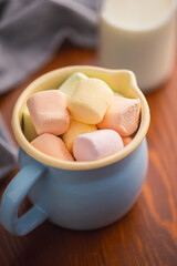 Sweet marshmallows candy in cup on kitchen table.