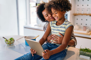 Happy african american single mother helping child with distance education. Online education - Powered by Adobe
