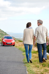 Old couple, walking and holding hands in nature on holiday, vacation or retirement with support. Back, man and woman with love, car and happiness in marriage together on a road trip or journey