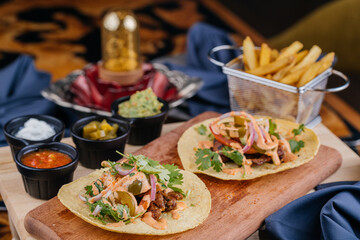 Mexican Tacos Al Carbon with french fries bucket served on wooden board isolated on table top view of arabic fastfood