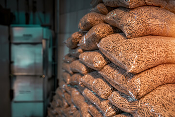Wooden pellets stacked in plastic bags, ready to be used for heating a house in winter, an alternative and sustainable source of fuel.