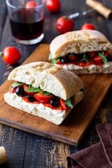 Ciabatta with cheese, tomatoes, sausage, olives and arugula. Sandwich. Italian food.