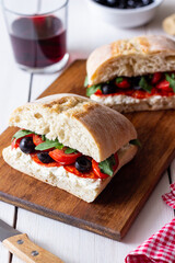 Ciabatta with cheese, tomatoes, sausage, olives and arugula. Sandwich. Italian food.