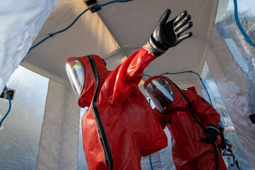 Firefighters in protective chemical suits in a decontamination shower