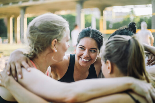 Smiling woman huddling with female friends