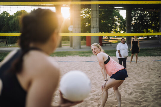 Mature woman looking at friend holding volleyball
