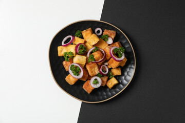 Fried tofu in a bowl on a black and white background