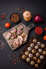 Raw quail eggs in a plastic box on a dark concrete background