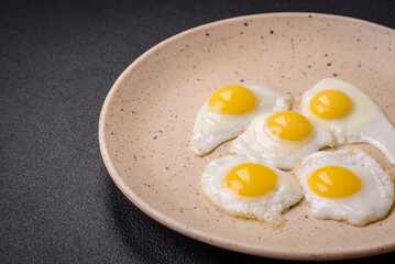 Delicious nutritious breakfast of fried quail eggs, bacon, legumes and cherry tomatoes