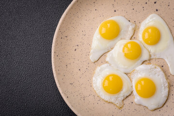Delicious nutritious breakfast of fried quail eggs, bacon, legumes and cherry tomatoes