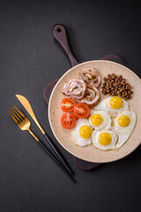 Delicious nutritious breakfast of fried quail eggs, bacon, legumes and cherry tomatoes