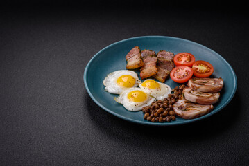 Delicious nutritious breakfast of fried quail eggs, bacon, legumes and cherry tomatoes