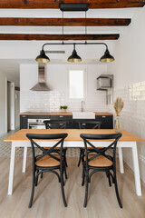 Dining table under vintage chandelier in studio apartment