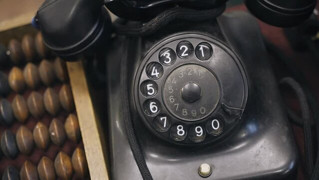 An antique black dial phone is on the table. Shooting from above