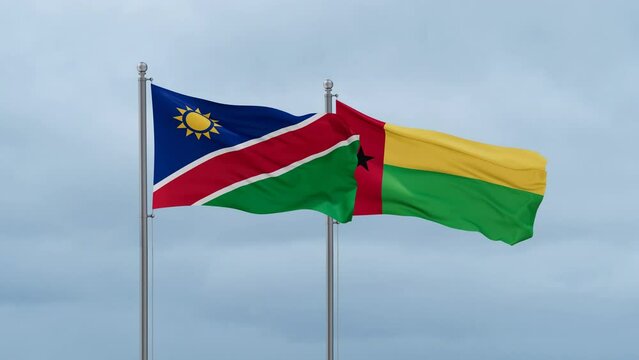 Guinea-Bissau flag and Namibia flag waving together on cloudy sky, endless seamless loop, two country relations concept
